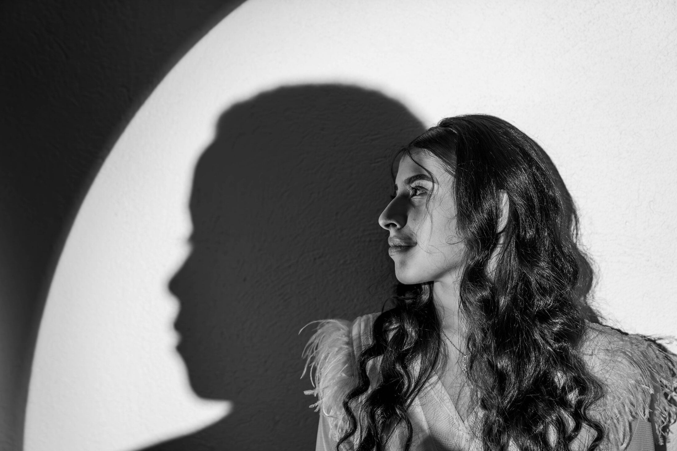 Retrato de perfil en blanco y negro junto a una sombra proyectada